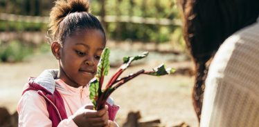 Girl learning about farming with her mother during a farm stay.