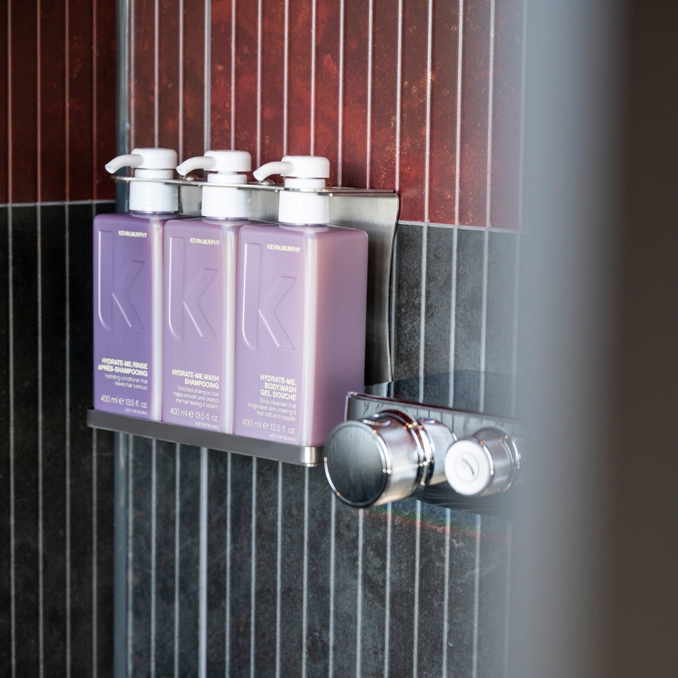 Three purple bottles of Kevin Murphy products in a shower