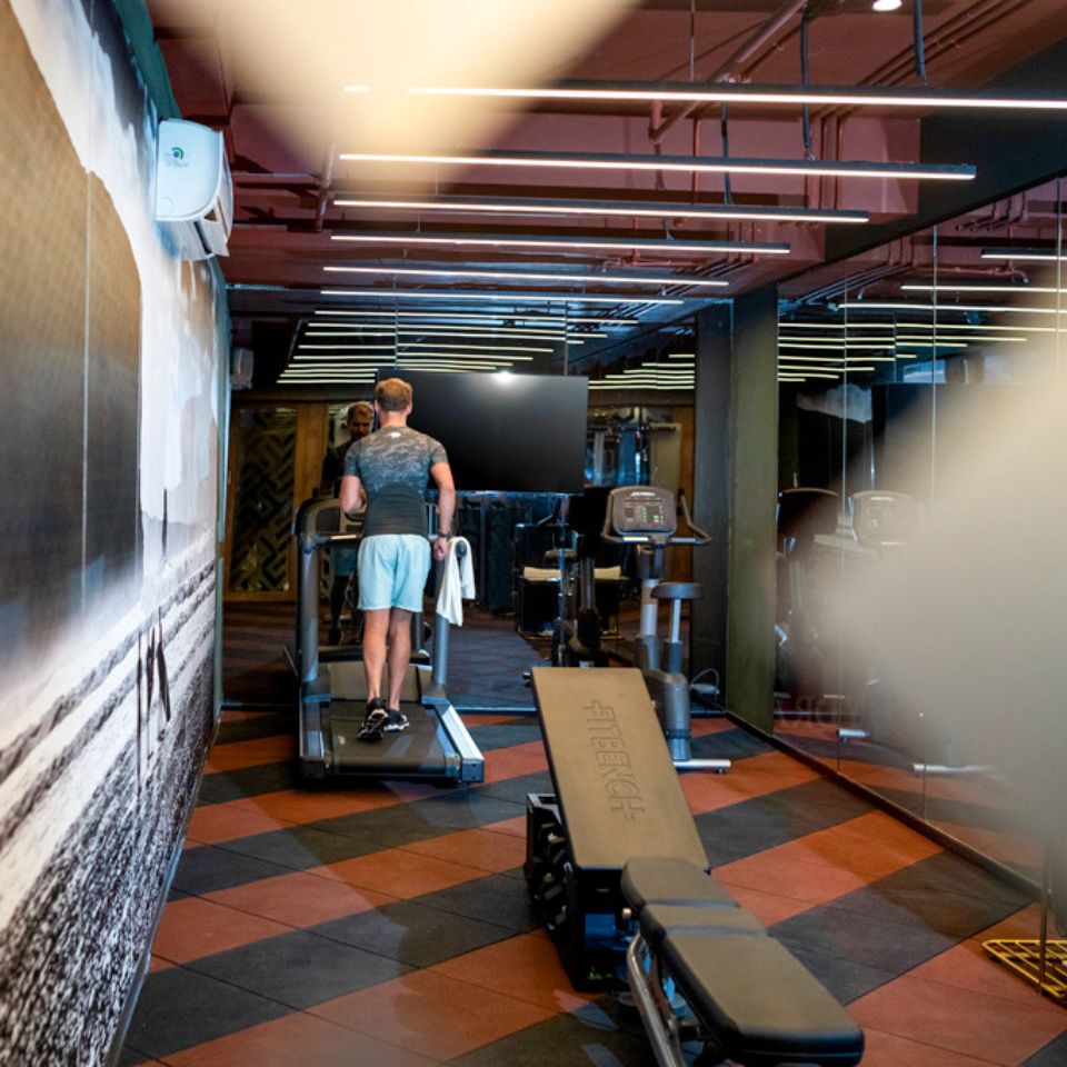 A person working out on a treadmill in the gym, there is other fitness equipment in the room