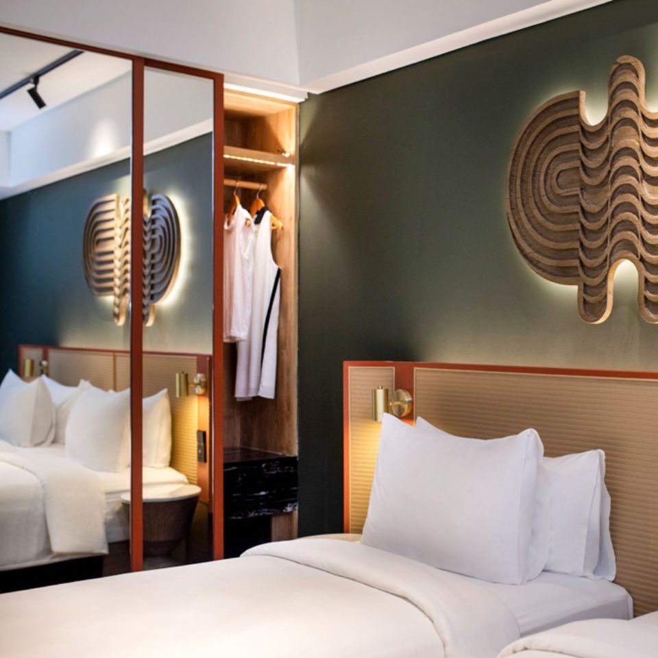 A guest rooms with twin beds and a wardrobe with a mirror