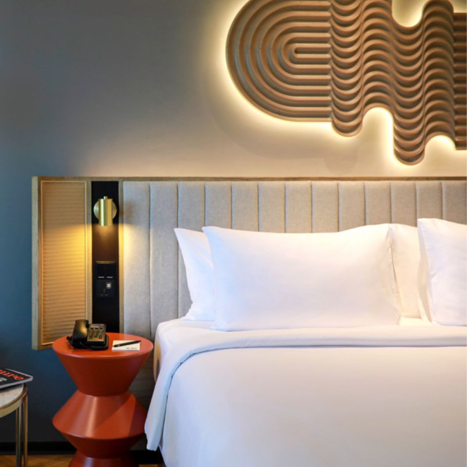 A double bed with an orange nightstand