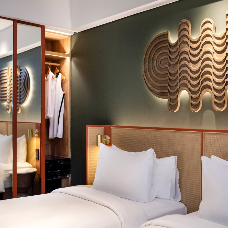 A guest rooms with twin beds and a wardrobe with a mirror