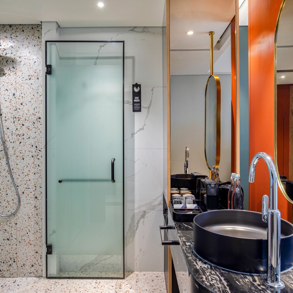 Bathoom with a shower, a frosted glass door and sinks