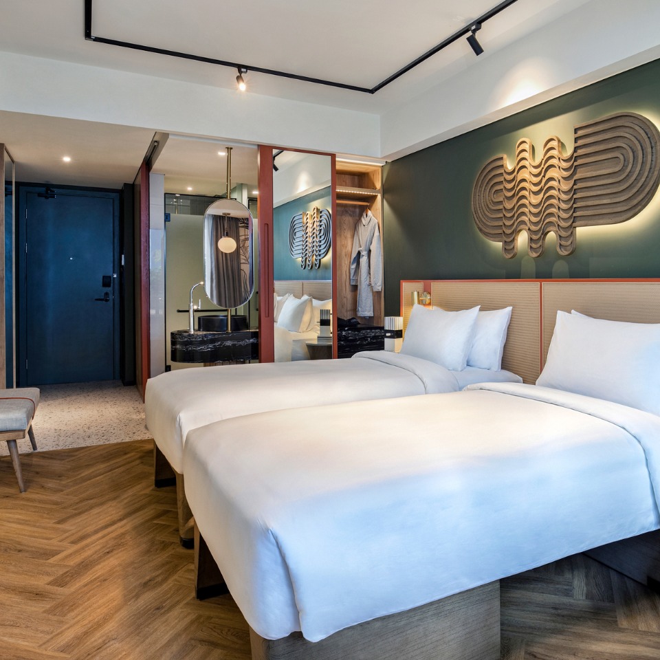 A guest rooms with twin beds and a wardrobe with a mirror