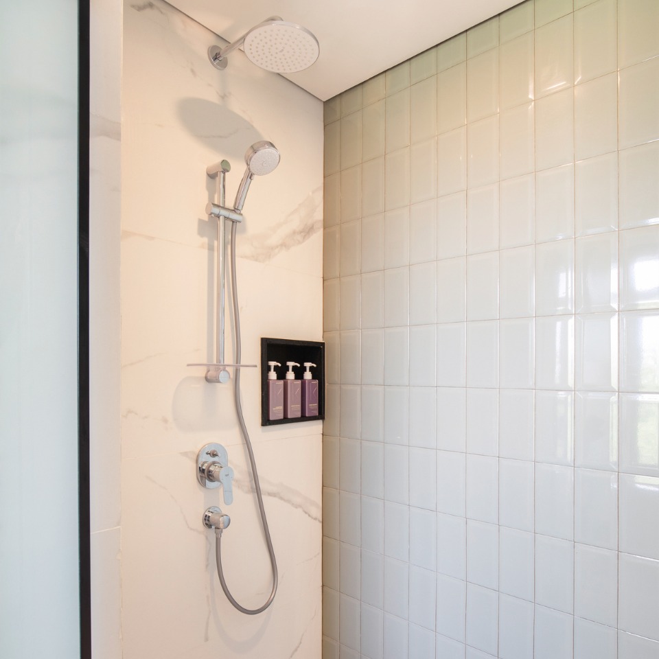 White tiled shower with Kevin Murphy products