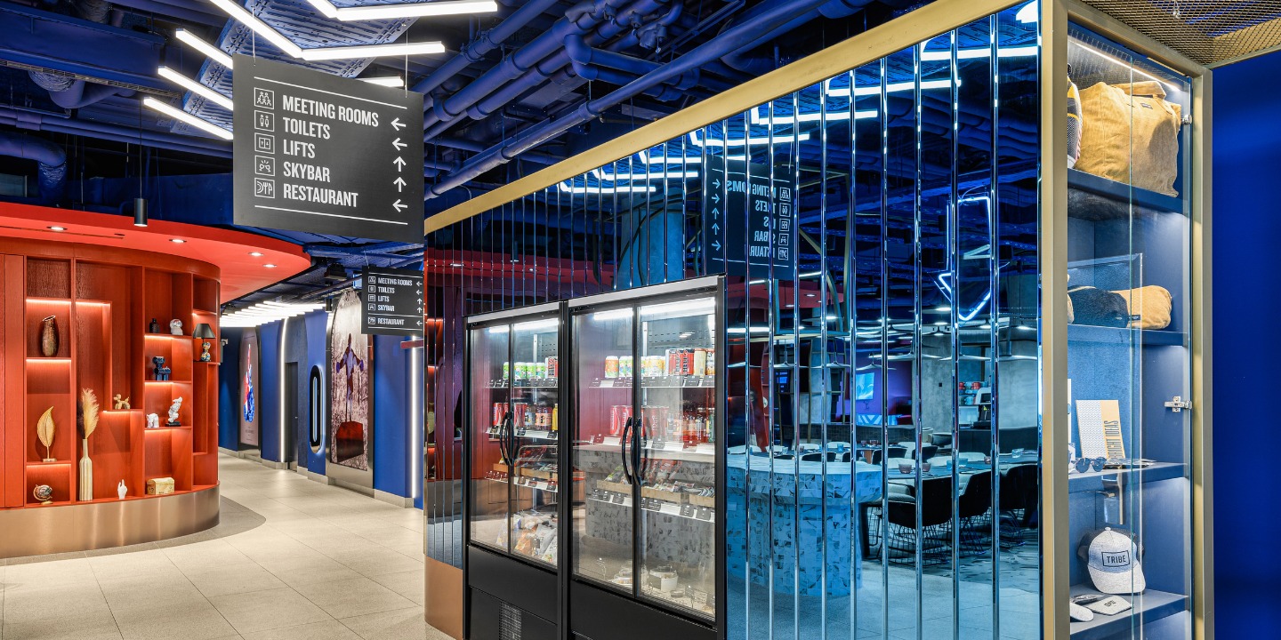 Modern lobby area with directional signs, vending machines, and stylish decor showcasing a vibrant atmosphere and accessible amenities.