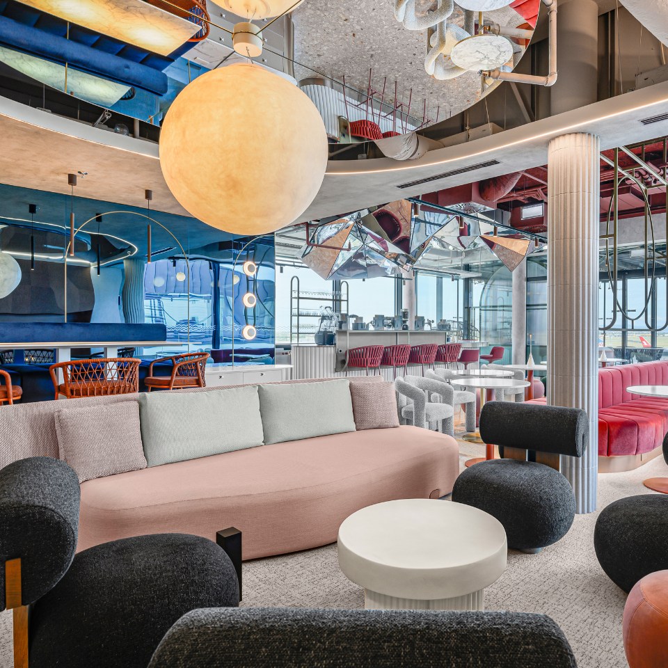 Stylish lounge with colorful seating, modern decor, and a large pendant light, reflecting a vibrant, contemporary atmosphere.