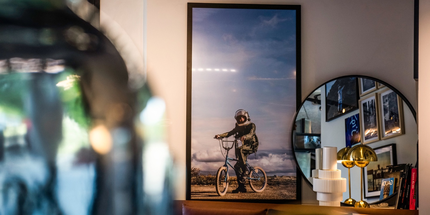 Decoration at TRIBE Carcassonne with a picture in a frame, a mirror, books and a lamp