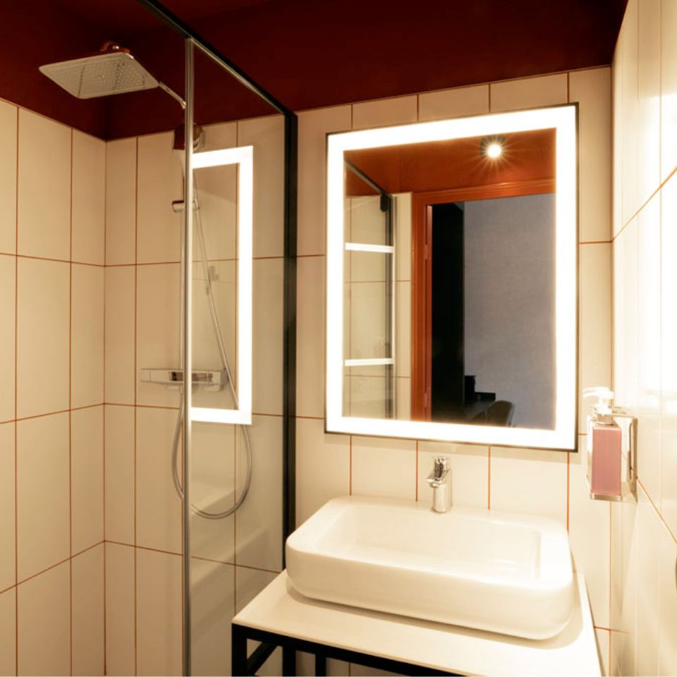 Bathroom with rain shower and illuminating mirror.