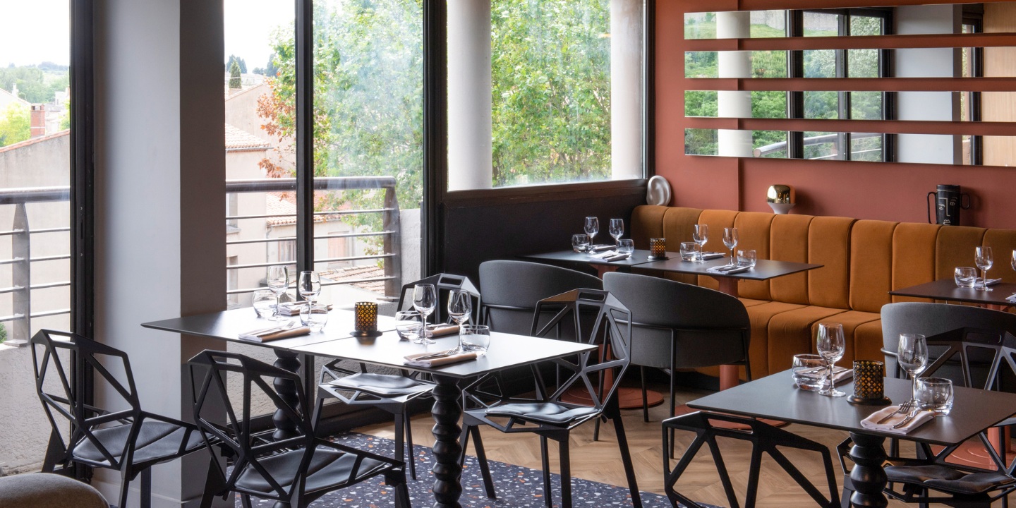 Restaurant dining area with small round tables and view of medieval city