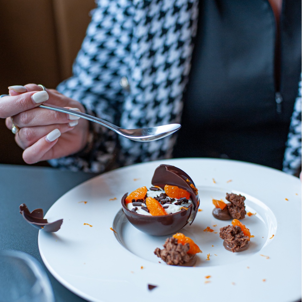 A chocolate dessert on a plate being eaten by someone