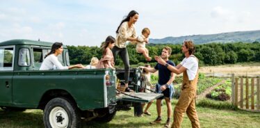 people stepping out of the back of a green pickup truck