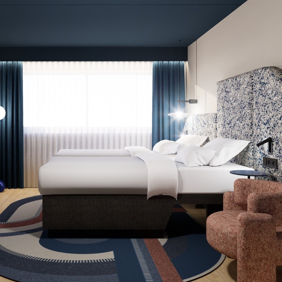 A hotel room featuring twin beds, a desk, a cozy chair, and a large window with sheer curtains, all in a contemporary style.