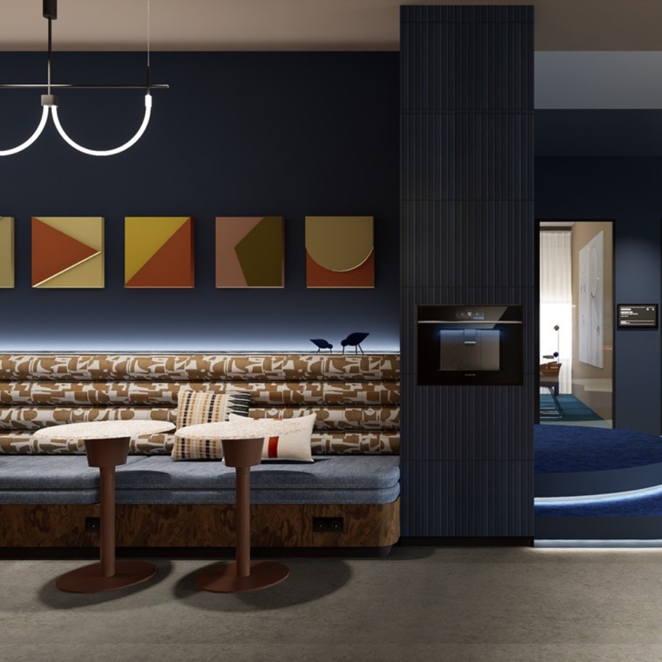 Modern lounge area featuring abstract artwork, stylish seating, and two round tables against a navy wall backdrop.