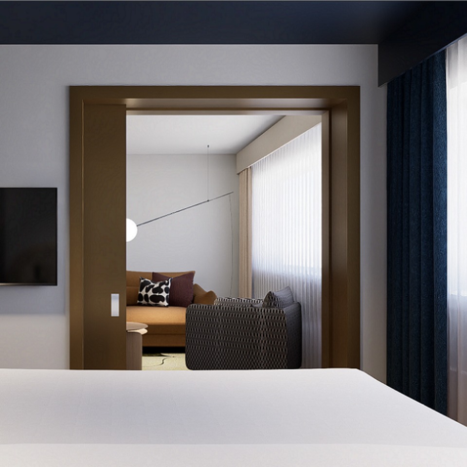 A connecting hotel room, looking into the adjoining room which features a living room.