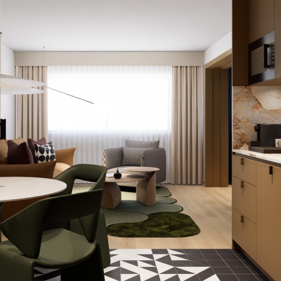 A hotel room with a living area, there are several couches and chairs. The room is designed in earth and natural tones.