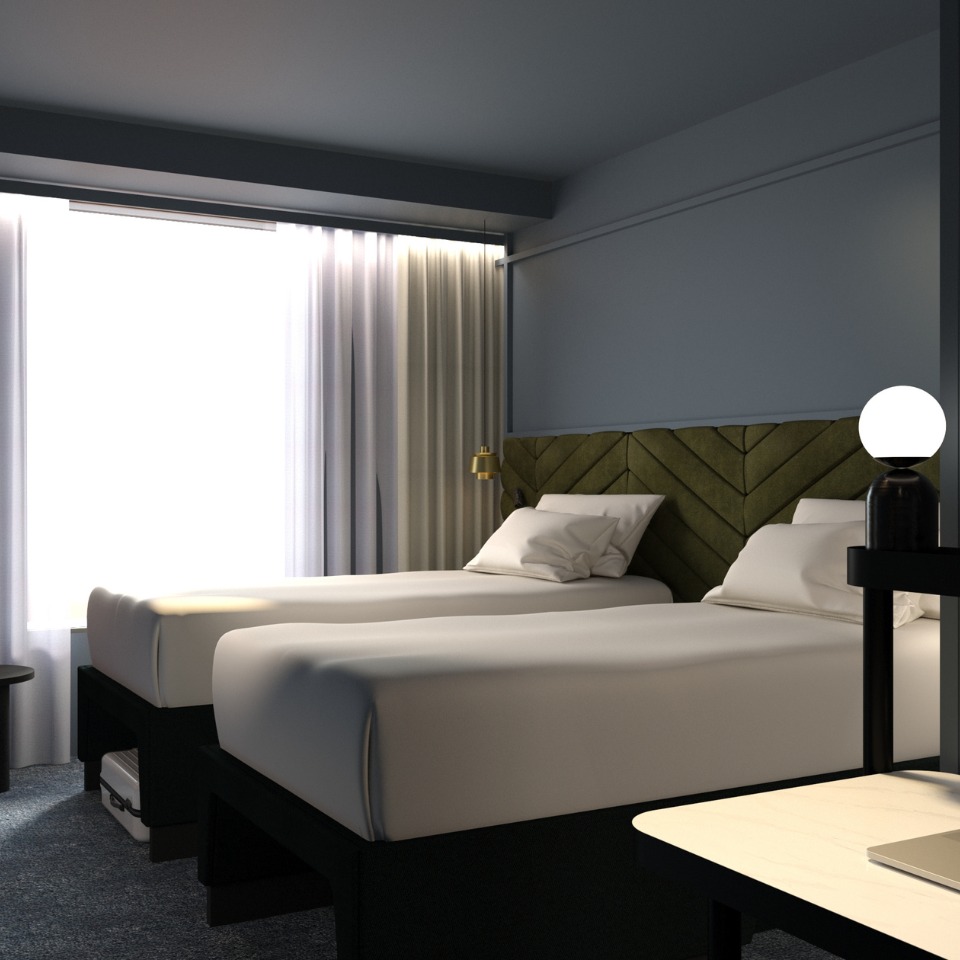 Cozy hotel room featuring two twin beds, a green headboard, modern lamp, and sheer curtains letting in natural light.