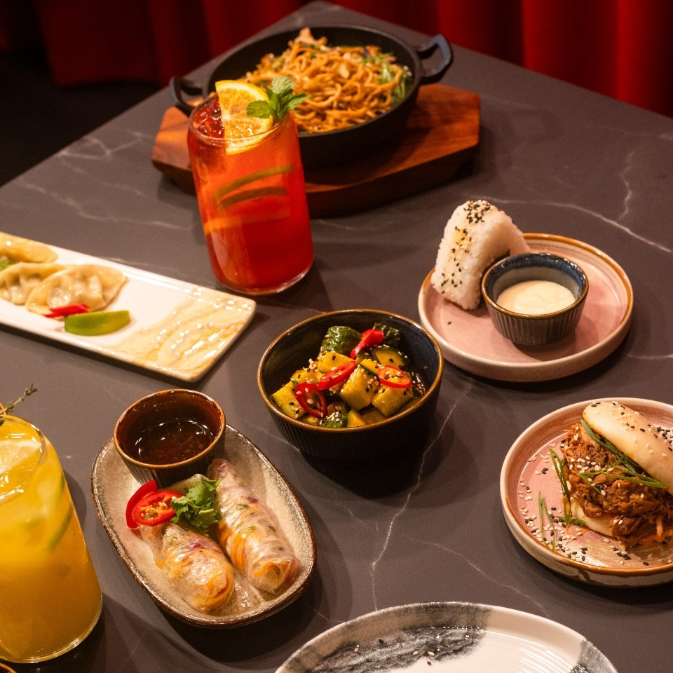 A table set with various dishes and drinks, showcasing a colorful spread of food for a gathering.