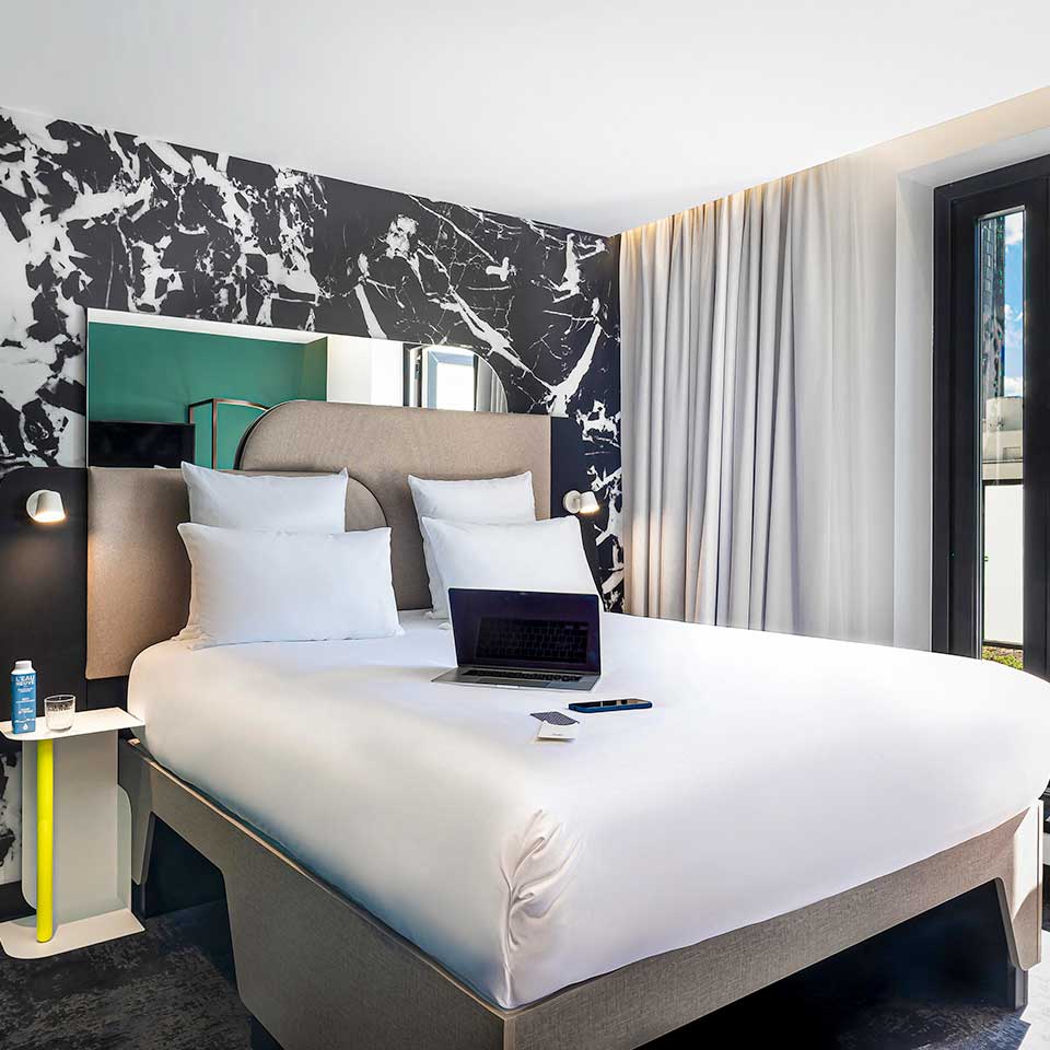 Laptop on top of Double bed with small side table