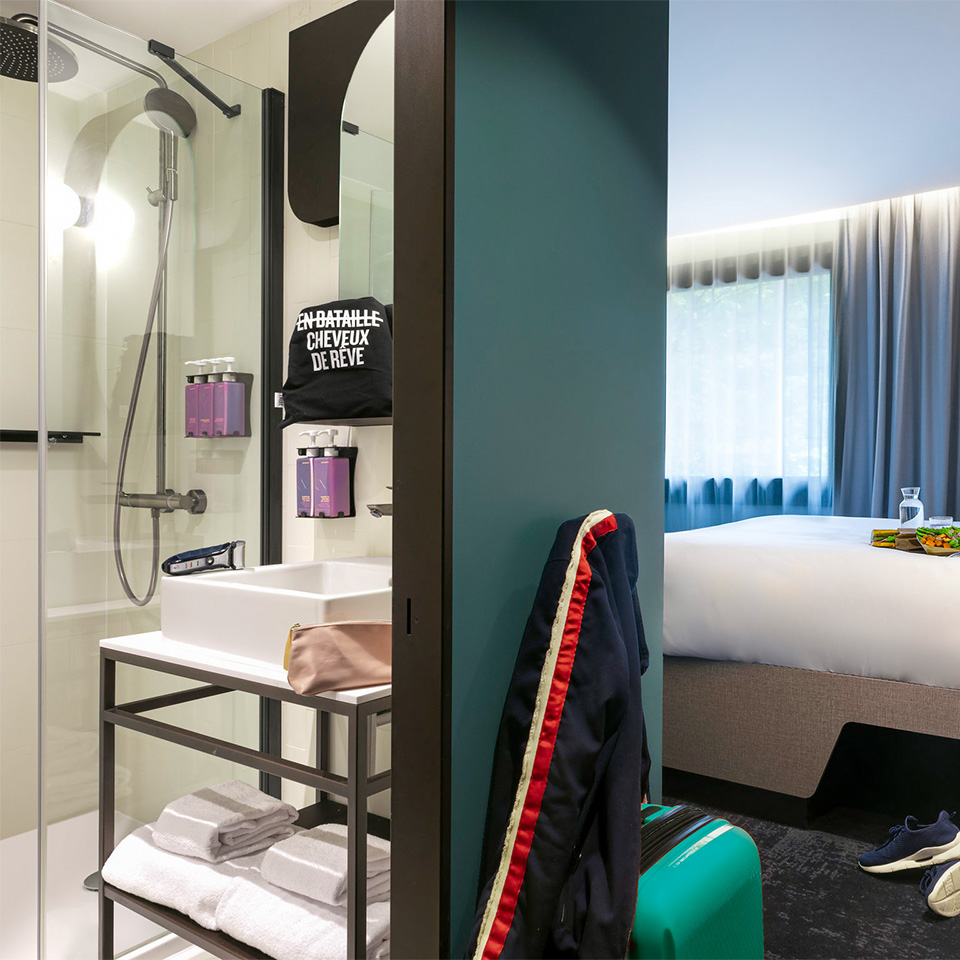 Comfort Double - View of bathroom and with walk-in shower leading to hotel room with double bed