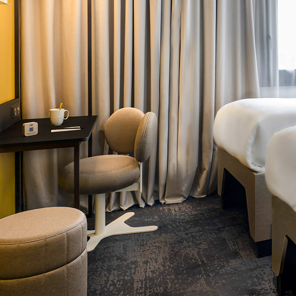 Small wall mounted desk with beige desk chair and matching foot rest