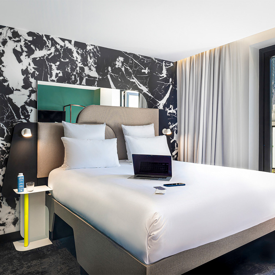 Laptop on top of Double bed with small side table