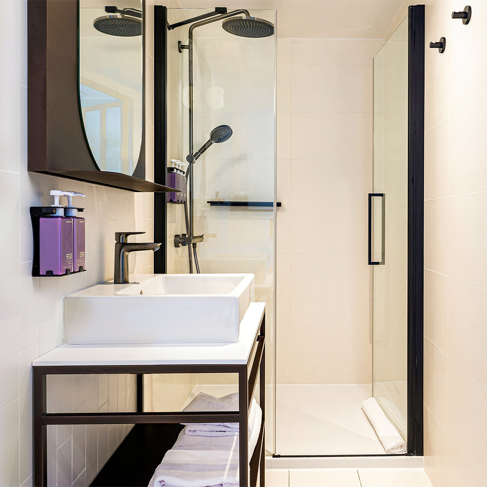 White bathroom with rain shower and make-up mirror