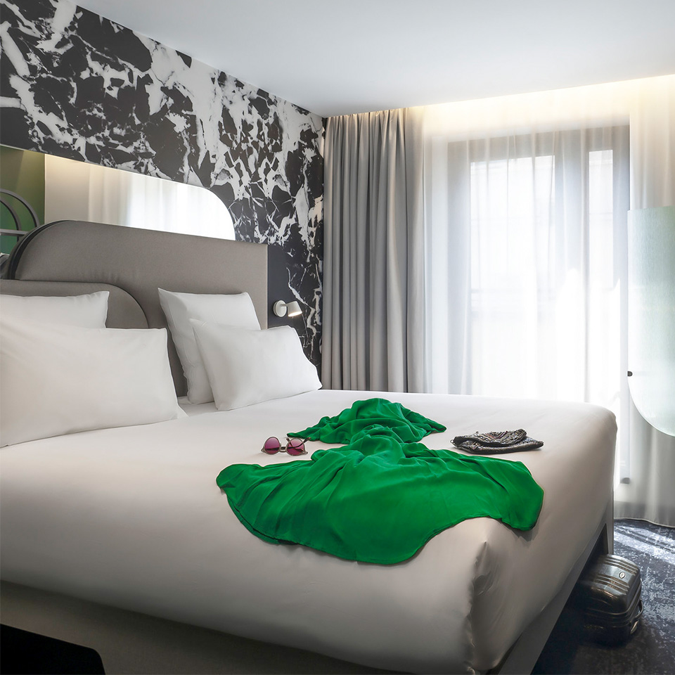 A Double bed with Luxe linens next to a balcony door