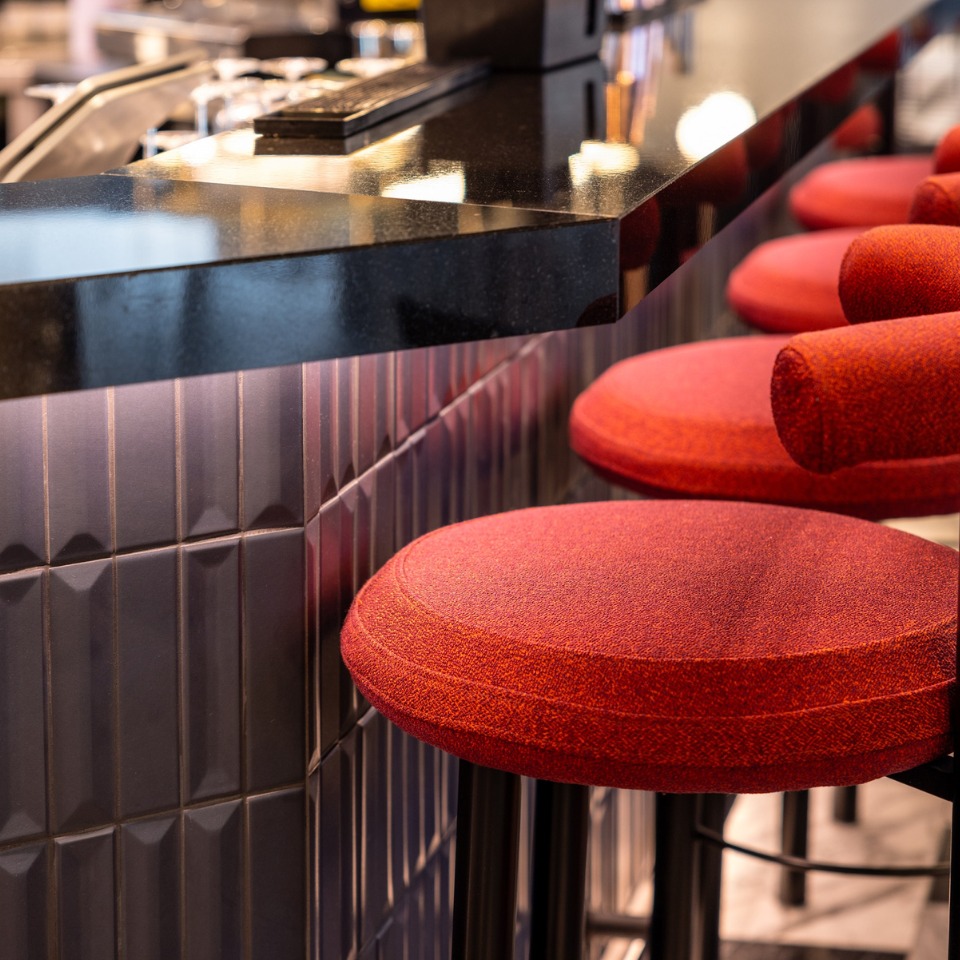 Red bar stools next to a bar