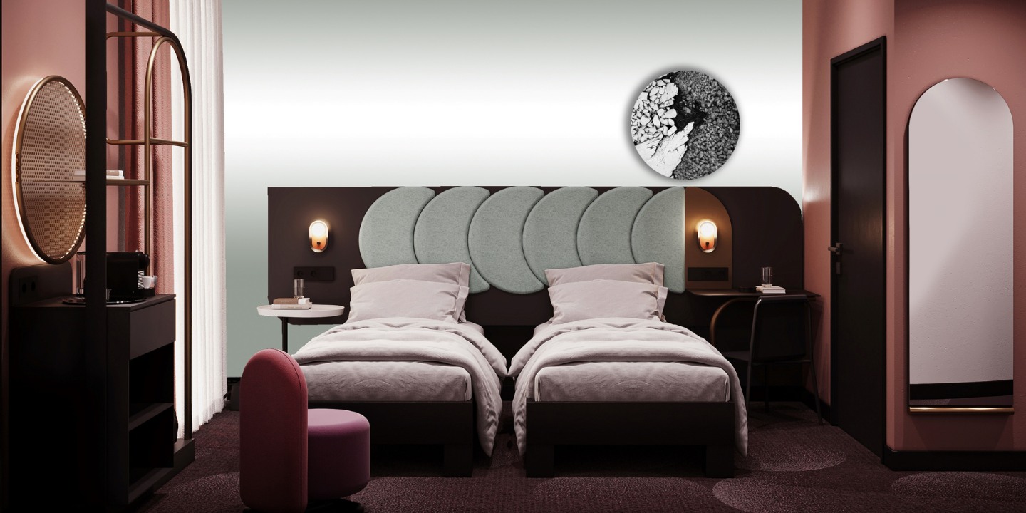 Modern hotel room with two twin beds, soft grey headboard, minimalist decor, and a round artwork, featuring a pink accent chair.
