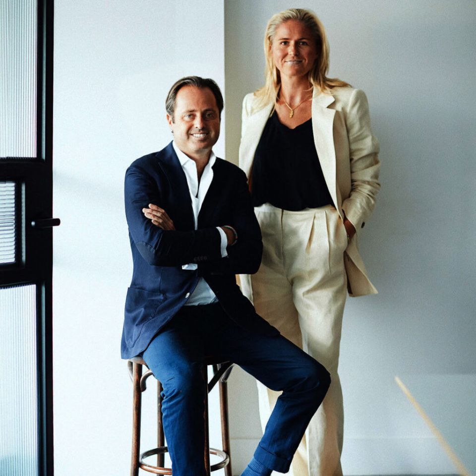 Melissa Peters is standing next to Marc, he is wearing a dark blue suit and she is waring a white suit