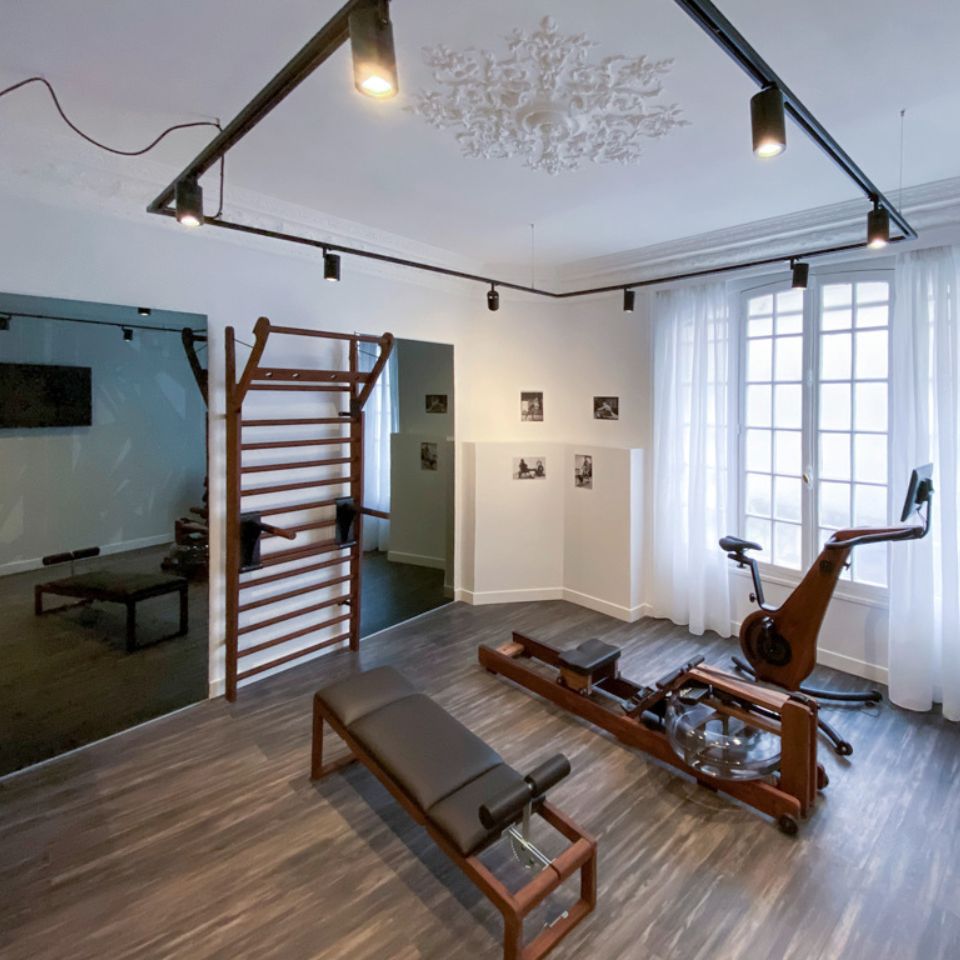 A gym with a mirror and different fitness equipment