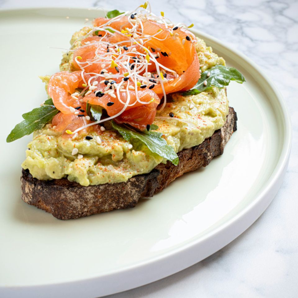 A slice of bread with avocado and salmon on it