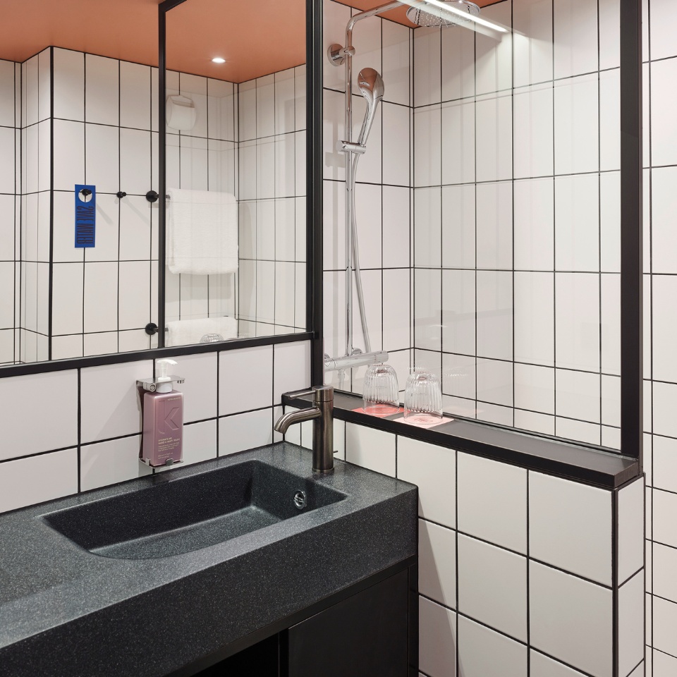 Black sink with a mirror and two glases on coasters