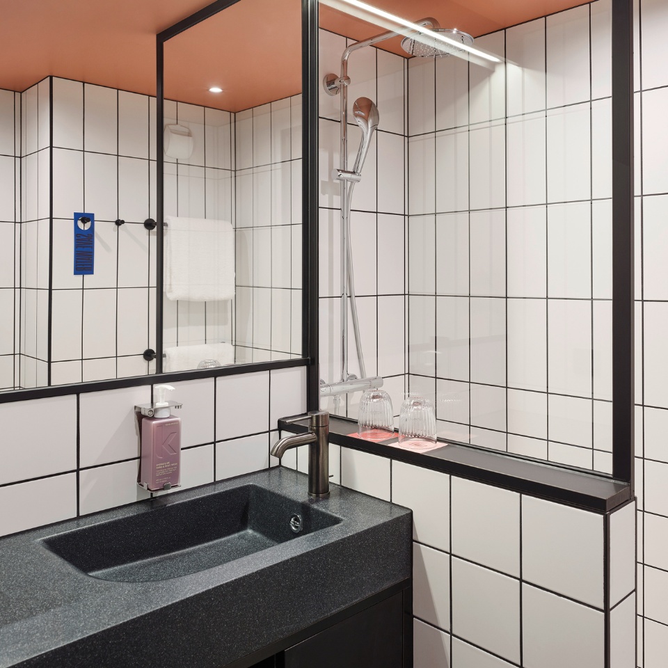 Black sink with a mirror and two glases on coasters