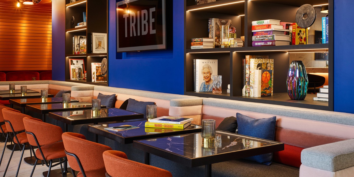Social Hub with several orange and blue chairs, couches and decorations on the walls, like pictures and shelves