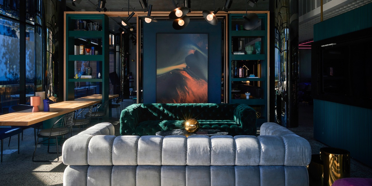 Two couches facing each other with a small coffeetable in the middle. In the background is a TV screen and a shelf with decoration on it