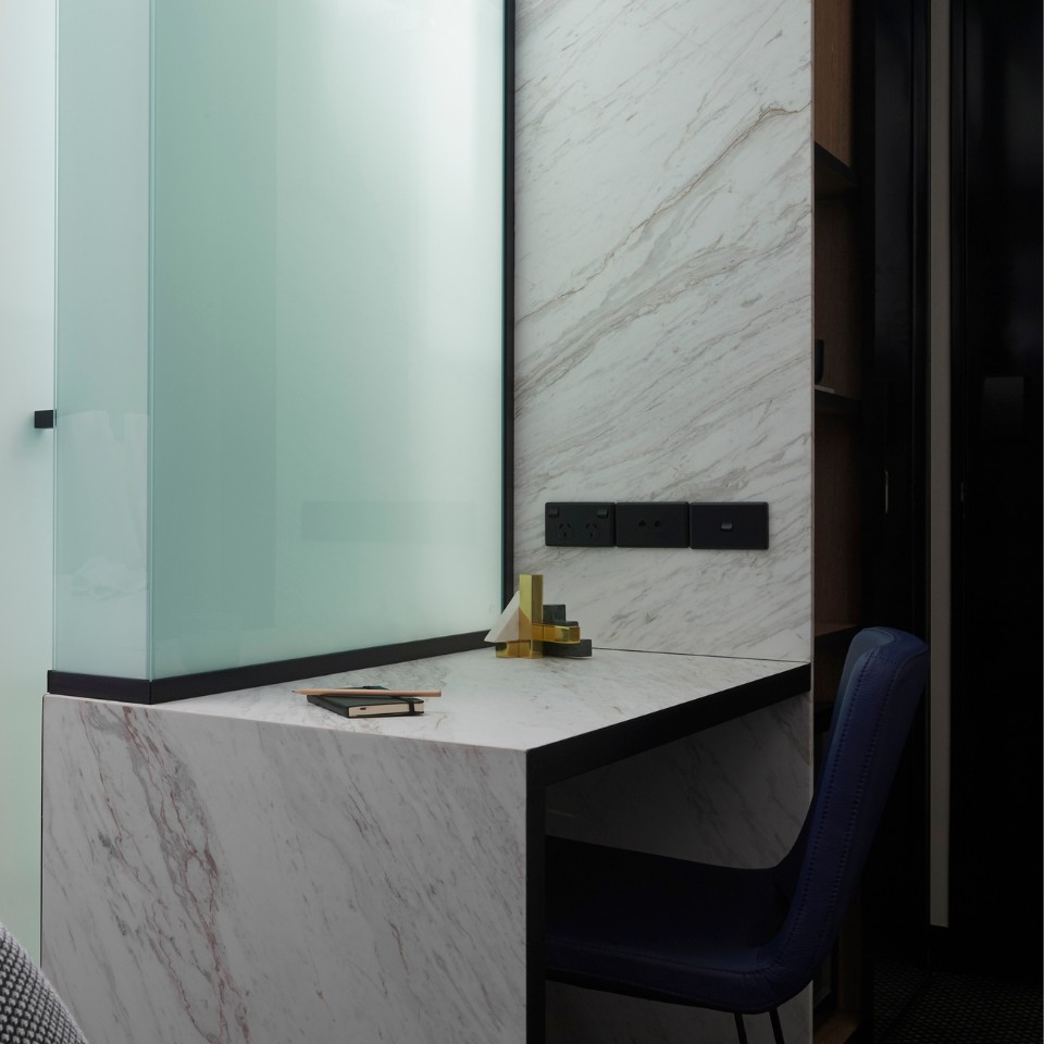 marble desk with stationary on top and a blue chair in front of it