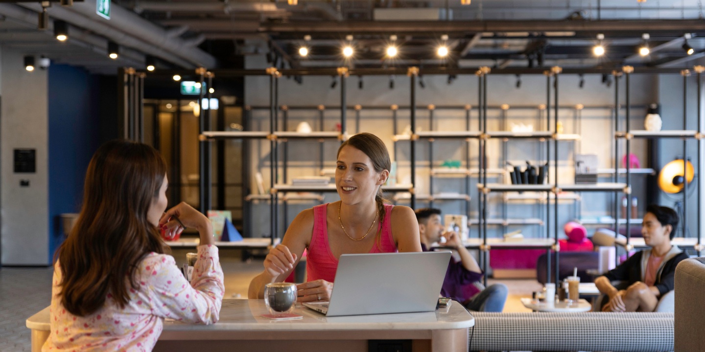 Two people engaging in conversation in a lively social hub.