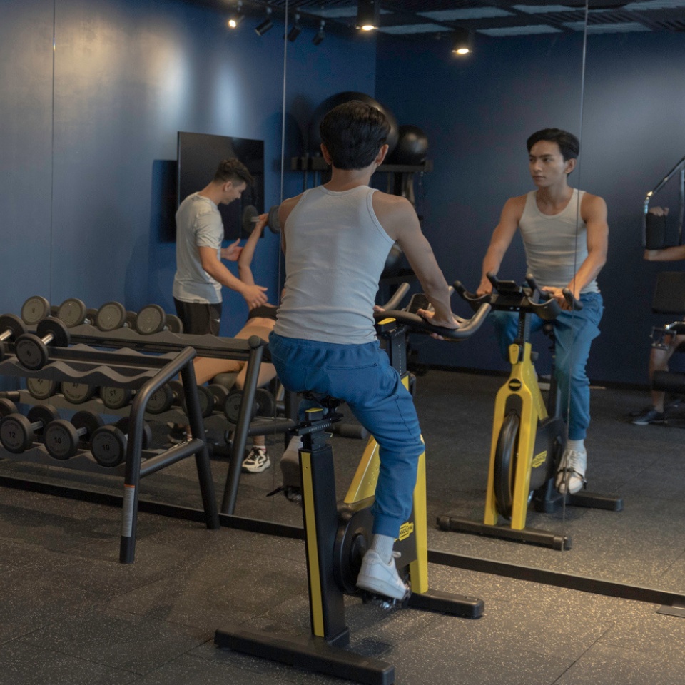 A woman excercising on a bike in a modern gym.