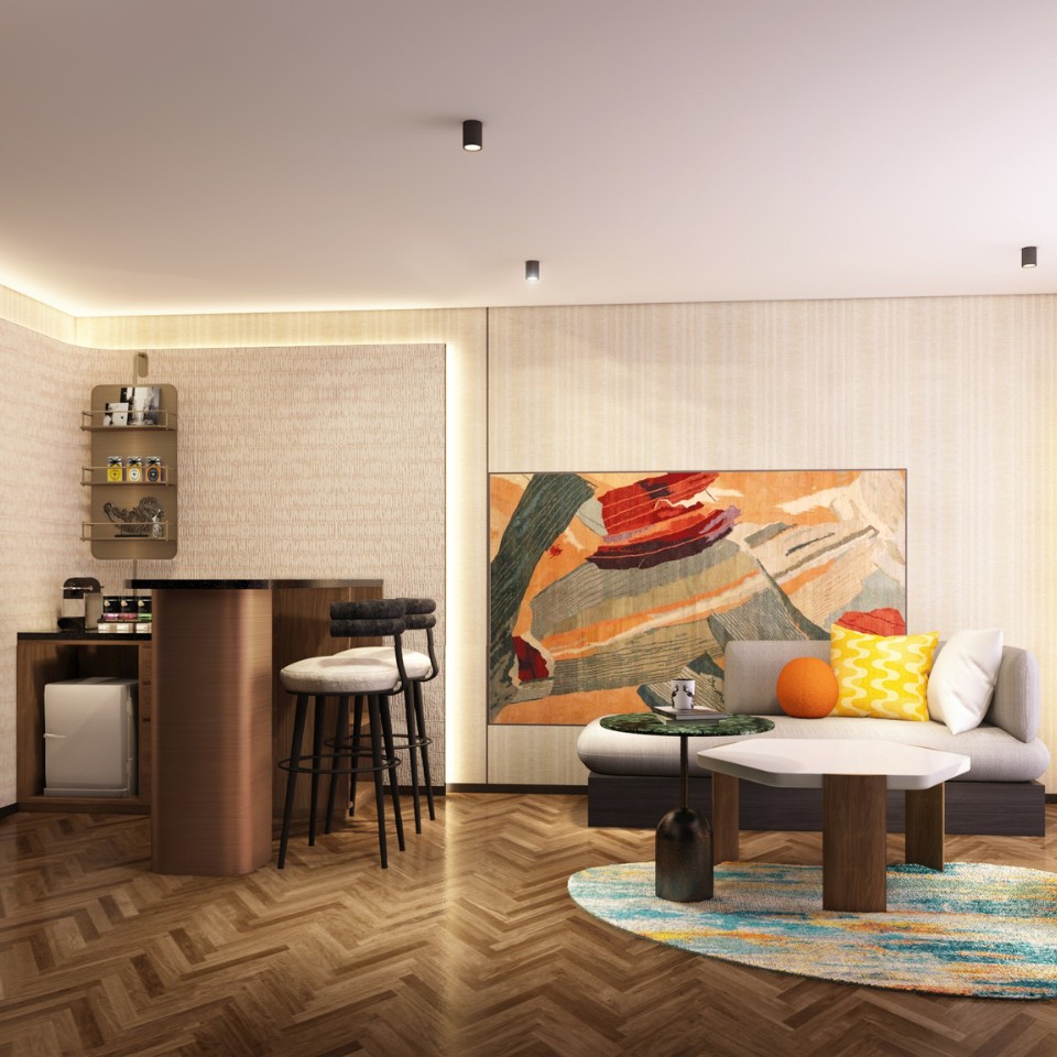 Modern living area with abstract art, a cozy sofa, bar stools, and a round coffee table on a colorful rug with herringbone flooring.
