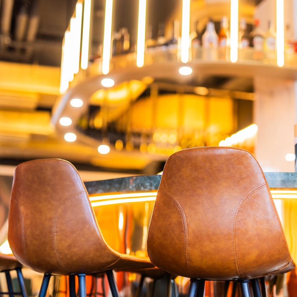 Close up of brown leather chairs positioned on the bar