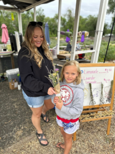 young girls with a woman holding picked flowers